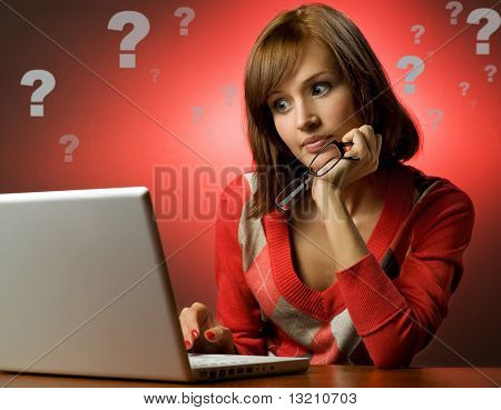 彼女のラップトップに取り組んでの美しい若い女性
