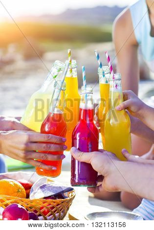 Group of friends holding drinks at the summer picnic. Close up