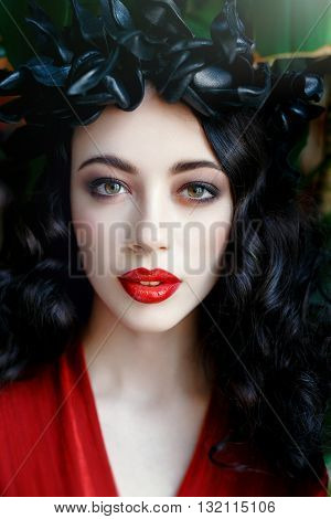 Portrait of a beautiful young woman in a wreath on had. beauty girl with red lips. Female face with clear skin close-up. Skincare