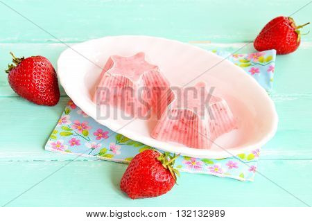Homemade strawberry ice cream. Fresh and flavorful strawberry ice cream on a plate. Frozen strawberry yogurt. Cold sweet berry dessert. Simple summer dessert. Fresh strawberries. Wooden background