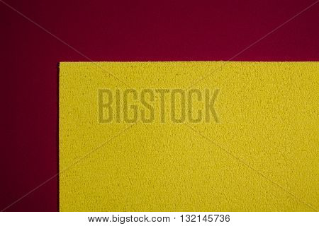 Eva foam ethylene vinyl acetate sponge plush lemon yellow surface on red smooth background