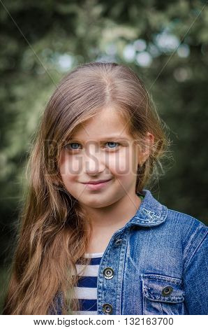 Cute little girl with long brown hair and blue eyes, summer portrait.