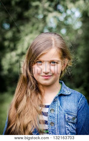 Cute little girl with long brown hair and blue eyes, summer portrait.