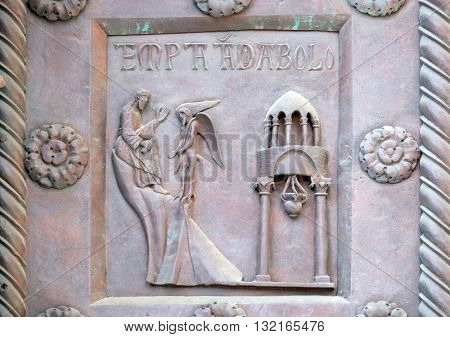 PISA, ITALY - JUNE 06, 2015: Temptation of Christ on the San Ranieri gate of the Cathedral St. Mary of the Assumption in Pisa, Italy on June 06, 2015