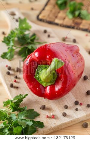 A photo of a fresh red pepper on a cutting board
