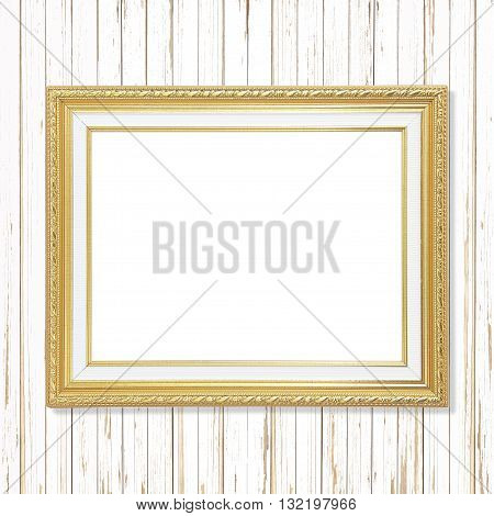 Antique gold frame on white wooden wall.  Empty picture frame on white wooden wall.