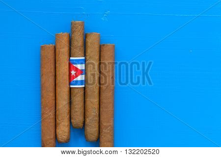 Detail of luxury Cuban cigars on the blue desk