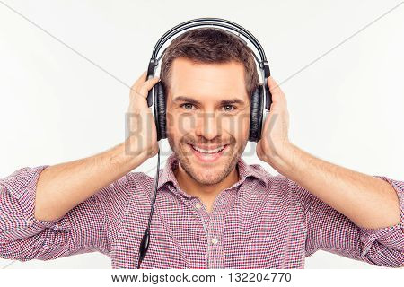 Cherrful man touching his headphones 
on a white background