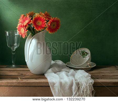 Still life with orange gerbera daisy flower and empty cup