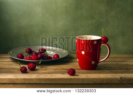 Still life with cherries and red cup