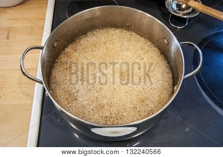 boiling maple sap to make maple syrup on stove in pot pan