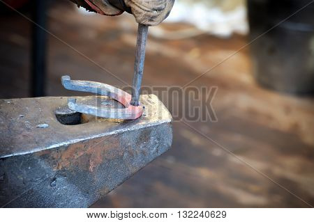 Blacksmith forges a horseshoe in a smithy