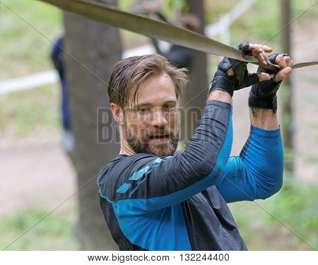 STOCKHOLM SWEDEN - MAY 14 2016: Man trying to maintain his balance on a slack rope in the obstacle race Tough Viking Event in Sweden April 14 2016