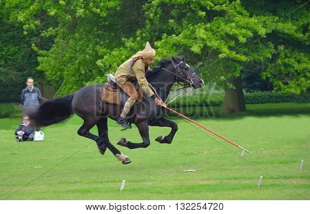Silsoe, Bedfordshire, England - May 30, 2016: Demonstration of the sport of Tent Pegging at full gallop  by a member of the Punjab Lancers in World War One uniform