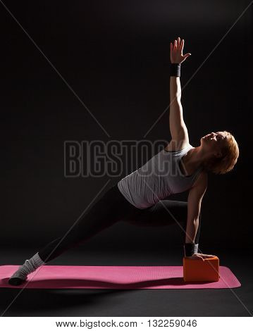 Young woman practicing yoga, Trikonasana / Bikram triangle left
