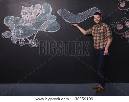 Portrait of freelance man posing near black wall in full length. Happy man in jeans and thirt making business over black background.
