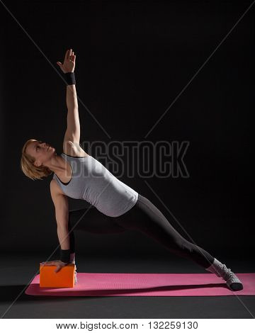 Young woman practicing yoga, Trikonasana / Bikram triangle right