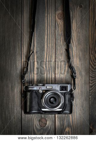 Retro film photo camera on the wooden background.