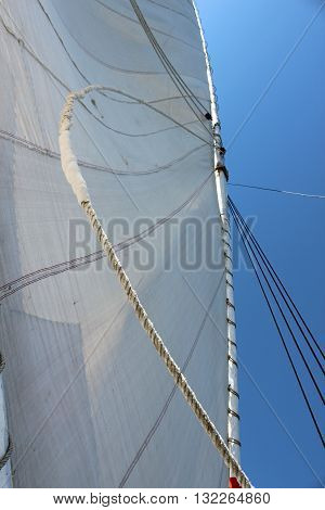 A streched sail of a boat with the blue background of sky