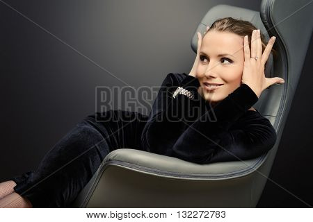 Portrait of a stunning fashionable model sitting in a chair in Art Nouveau style. Business, elegant businesswoman. Interior, furniture.