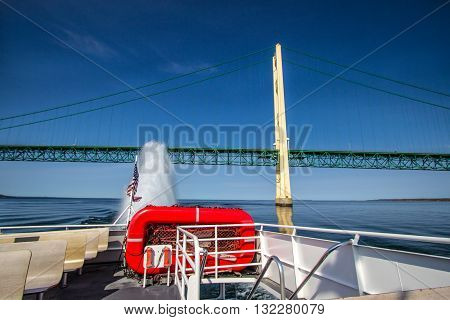 Mackinaw Island, Michigan, USA - May 6, 2016: Stern view of a Star Line passenger ferry with the Mackinaw bridge in the background. Star Line transports tourists and goods from the mainland to Mackinaw Island.