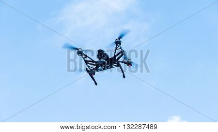 The Quadcopter with camera flying on a clear sunny sky sunset background with nice lens flare