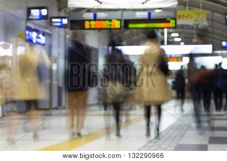 Corporate business people commuting to work by Tokyo public transport. Unrecognizable people blured in motion while rushing to train platforms.