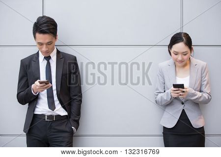 Business people team use smart phone in the office shot in Hong Kong asian woman and man