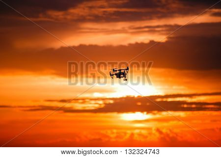 drone with remote control. Dark silhouette against colorfull sunset. Soft focus. Toned image