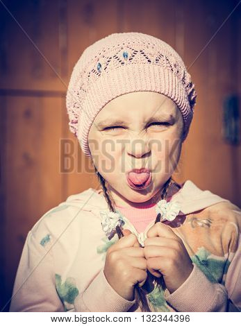 Saddened by the child against the wall showing tongue. Photos in retro style.