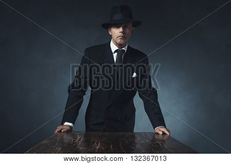Bossy Vintage 1940 Businessman Standing Behind Wooden Table.
