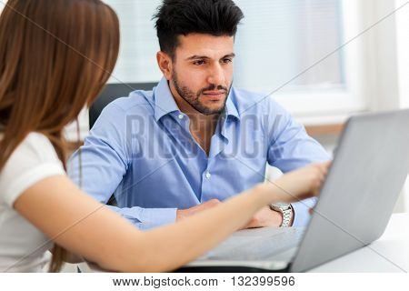 Two young business partners discussing plans or ideas at meeting