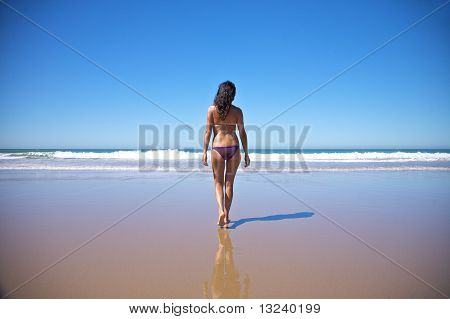 해변에서 물 쪽으로 걷는 여자