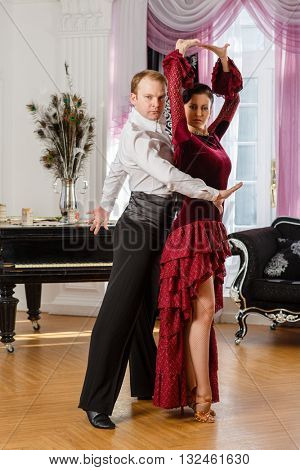 Dancing young couple in the room.