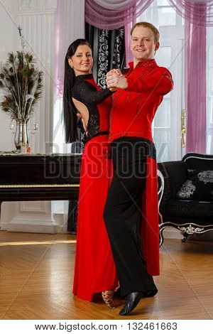 Dancing young couple in the room.