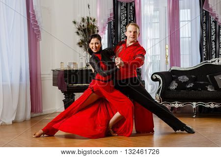 Dancing young couple in the room.