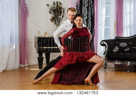Dancing young couple in the room.