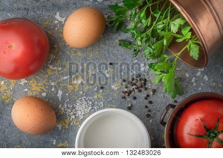 Ingredients for baked eggs with tomatoes on the stone table top view