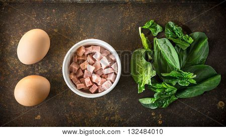 Ingredients for Florentine eggs with spinach on the rusty background