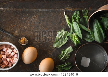 Ingredients for Florentine eggs with spinach on the rusty background top view