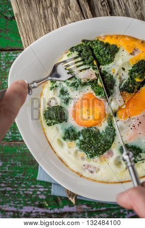 Eating Florentine eggs with purred spinach vertical