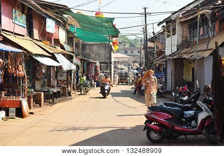 GOKARNA KARNATAKA INDIA - JANUARY 29 2016: A man wearing orange shawl at his head walking along street  in Gokarna city