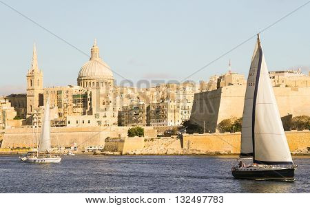 Panoramic view of Valleta harbor with sailing boats and Fort Saint Angelo
