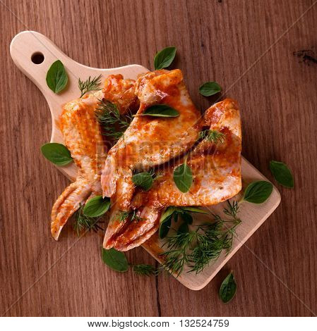 Marinated Chicken Wings On Wooden Board With Herbs