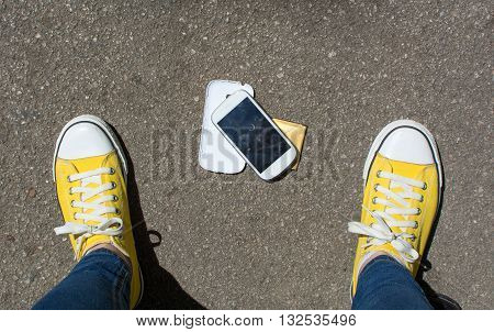 Disassembled Smartphone On The Ground In Front Of Person