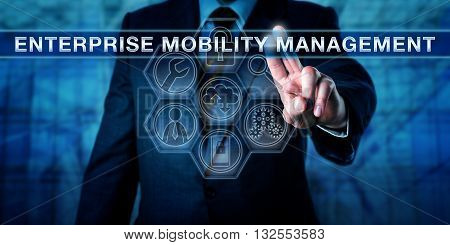 Manager is touching ENTERPRISE MOBILITY MANAGEMENT on an interactive virtual control display. Mobile technology and computing security concept. Business metaphor. Application tool icons in matrix.