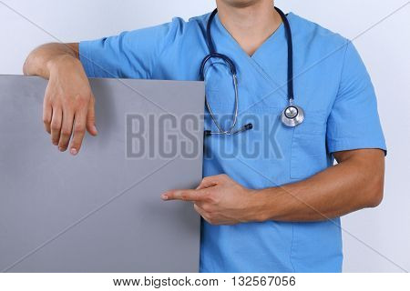Man doctor holding blank banner isolated on white background