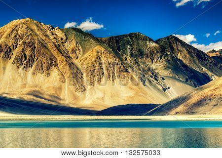 Beautiful Mountains and Pangong tso (Lake). It is a huge lake in Ladakh extends from India to Tibet. Leh Ladakh Jammu and Kashmir India. Himalayan mountains in background. Colourful stock image.