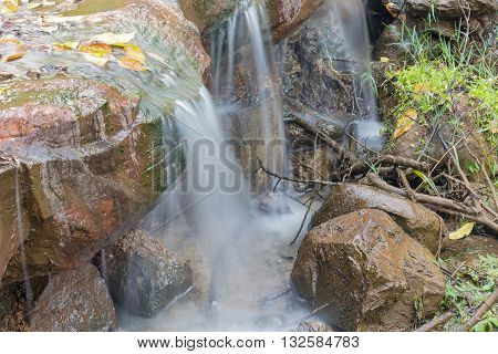 Deep forest Waterfall small Beautiful of waterfalls with soft flowing water and large colored rocks.( Blur blurred Waterfall)