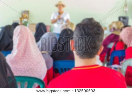 Blurred abstract background of university students sitting in a lecture room with teacher of the out Community education: Blurry view from back of the classroom: Teachers day
